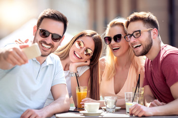 Canvas Print - Group of four friends take selfie in cafe