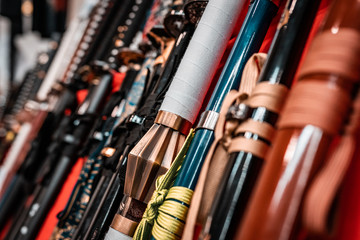 Oriental martial arts weapons, samurai katanas ready for fighting. Hand made swords, string hilt, warm colors. Ninja concept, assassin's kit. Armory rack on display.