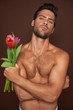 © Yakobchuk Olena - Topless muscular macho man with tulips bunch
