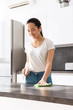 © Drobot Dean - Portrait of young asian girl cleaning table with detergent and rag in kitchen at home
