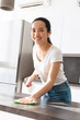 © Drobot Dean - Portrait of attractive asian woman cleaning table with detergent and rag in kitchen at home