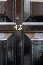 House Number 42 With The Forty Two On A Shiny Black Wooden Door