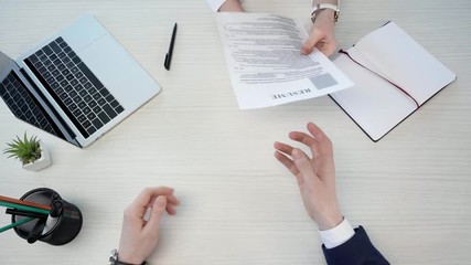 top view of man giving resume and leaving, while woman near blank notebook and laptop, throwing crumpled paper