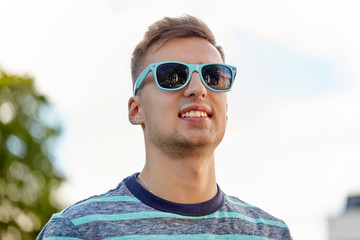 people concept - portrait of young man in sunglasses outdoors in summer 