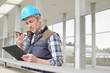 © goodluz - Architect on cellphone checking worksight progress
