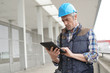 © goodluz - Lead architect checking tablet outside contemporary building