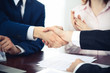 © rogerphoto - Business people shaking hands finishing up a meeting. Handshake at successful negotiation