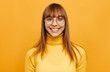 © PinkCoffee Studio - Woman portrait. Emotion. Beautiful young woman in eyeglasses is looking at camera and smiling, on a yellow background