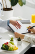 cropped view of nutritionist holding clipboard near patient with pen