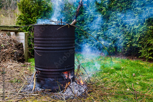 Fotomural A burning fire of garden waste in an old rusty barrel