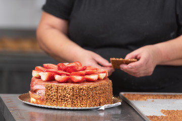 Wall Mural - Close up of Professional confectioner making a delicious cake in the pastry shop .