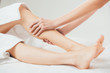 © LIGHTFIELD STUDIOS - partial view of masseur doing foot massage to adult woman in spa
