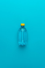 Plastic Water Bottle With Yellow Cap On The Blue Background