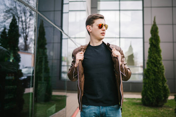 Wall Mural - A stylish man in a black T-shirt. Street photo