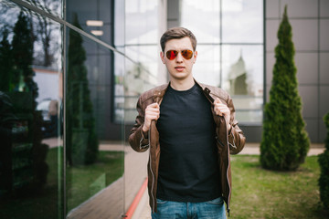 Wall Mural - A stylish man in a black T-shirt. Street photo