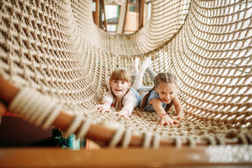 Wall Mural - Two girls poses in rope net, children game center