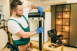 © Nomad_Soul - Worker with screwdriver repairs refrigerator door