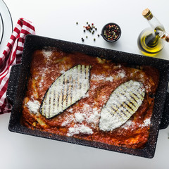 Wall Mural - Italian melanzane alla parmigiana dish, made of eggplants and tomatoes on a table, served in a plate. with cheese and basil. traditional cuisine