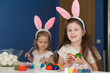 © erainbow - Girls paint easter eggs