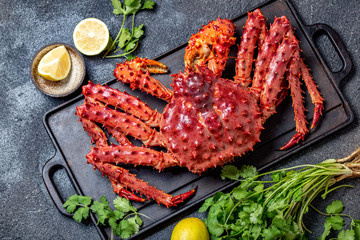 Wall Mural - Red king crab on gray background. King crab, lemon and cilantro, top view