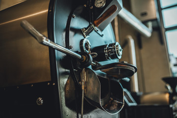 Coffee roasting in small roastery. Coffee roasting machine, Production of coffee.