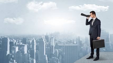Wall Mural - businessman looking forward to a city with binoculars from skyscraper concept