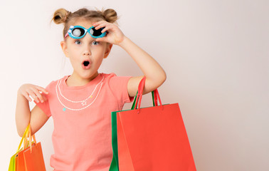 beautiful girl wearing dress and sunglasses holding shopping bags