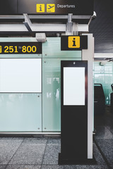 Wall Mural - A vertical view of the template of an electronic contemporary information desk with intercom and camera indoors of a modern airport terminal with a LCD screen mock-up as a departure board on the wall