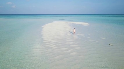 Wall Mural - 4k aerial drone footage - An attractive woman on a small island in the Maldives.  Asia