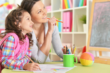 Poster - Portrait of mother and daughter sitting at table