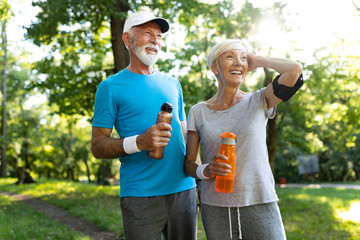 Wall Mural - Happy fit senior couple exercising in park