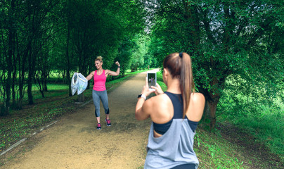 Girl taking a picture of a friend with trash bags after plogging. Selective focus on girl in background