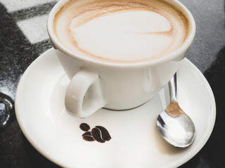 Cup of cappuccino coffee on dark table