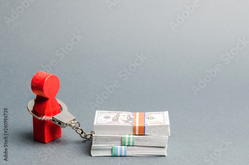 Fotografía A red man is handcuffed to a money