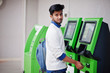 © AS Photo Family - Young asian man put his credit card for removes cash from an green ATM.