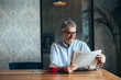 © cherryandbees - man reading newspapers in cafeteria