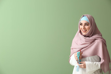 Poster - Muslim woman with tasbih on color background