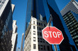 Stop sign on a street of New York City, modern buildings in background, USA.