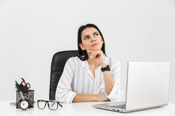 Wall Mural - Photo of european brunette businesswoman working on laptop in office isolated over white background