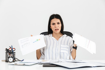 Wall Mural - Photo of tense brunette businesswoman 30s screaming and stressing while working with paper documents in office