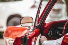 A Man Opens The Door Of A Red Vintage Car