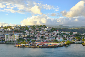 Wall Mural - Scenic view of little town Fort-de-France with cloudy blue sky - capital of small island Martinique in the Caribbean sea. Beautiful summer look of town on green tropical island