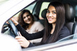 © F8  \ Suport Ukraine - Two attractive friendly young women enjoying a day trip to town viewed through the open window of their car grinning happily at the camera