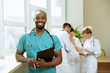Healthcare people group. Professional african american male doctor posing at hospital office or clinic. Medical technology research institute and doctor staff service concept. Happy smiling models.