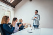 © bnenin - Colleagues giving the applause to successful young businessman leader in team meeting.