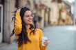 © bnenin - Gorgeous casual brunette in the town street, smiling and drinking coffee to go.