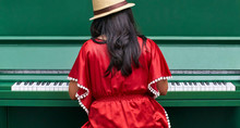 Lady In Red Playing On A Green Piano
