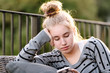 © Angela Lumsden/Stocksy - Close up of a teenage girl sitting outside using her phone at sunset