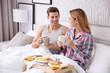 © Africa Studio - Happy couple having breakfast together in bed