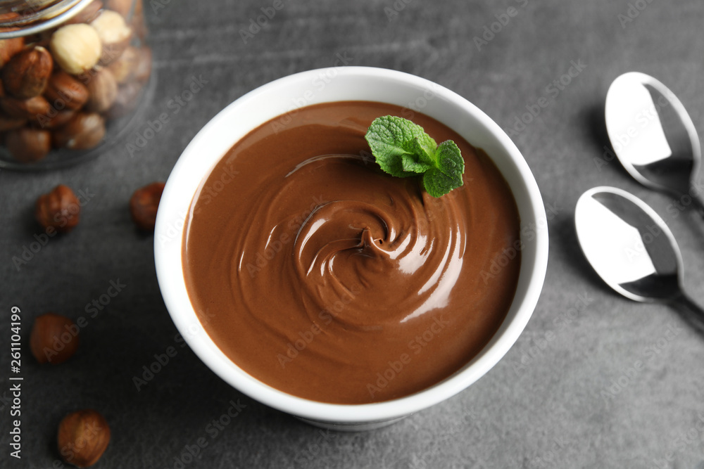 Obraz na płótnie Ceramic bowl with sweet chocolate cream and mint on table, view from above w salonie